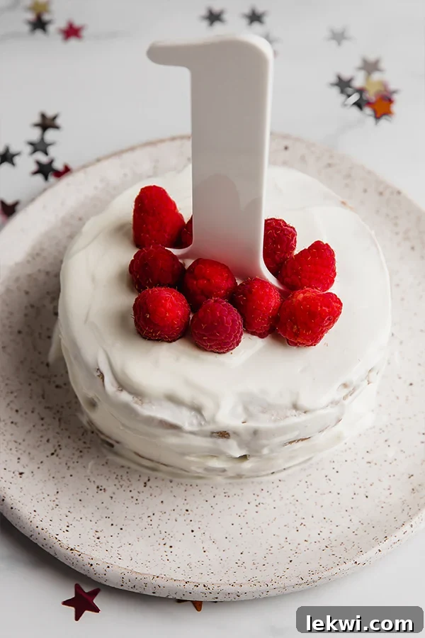 Raspberries and a number one on a cake.