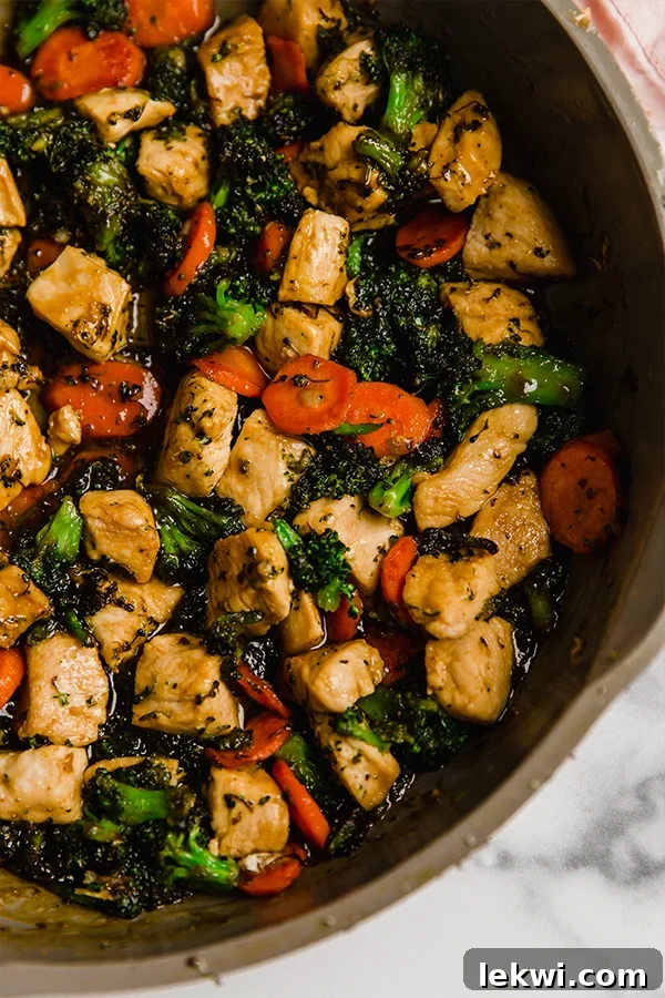 Honey Garlic Chicken Stir Fry being cooked in a large frying pan.
