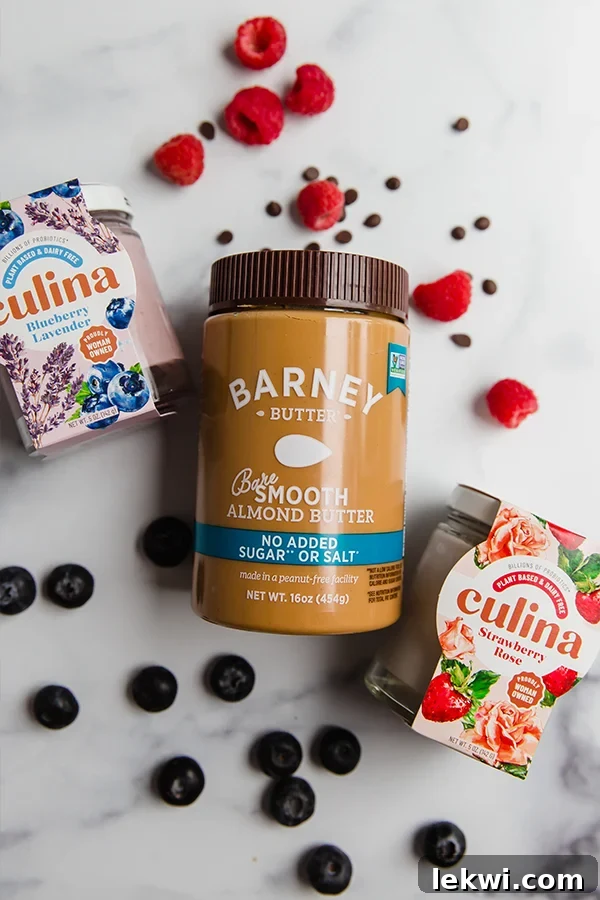 A close-up view of creamy almond butter and a vibrant culina coconut yogurt, ideal for topping healthy apple 'donuts'.