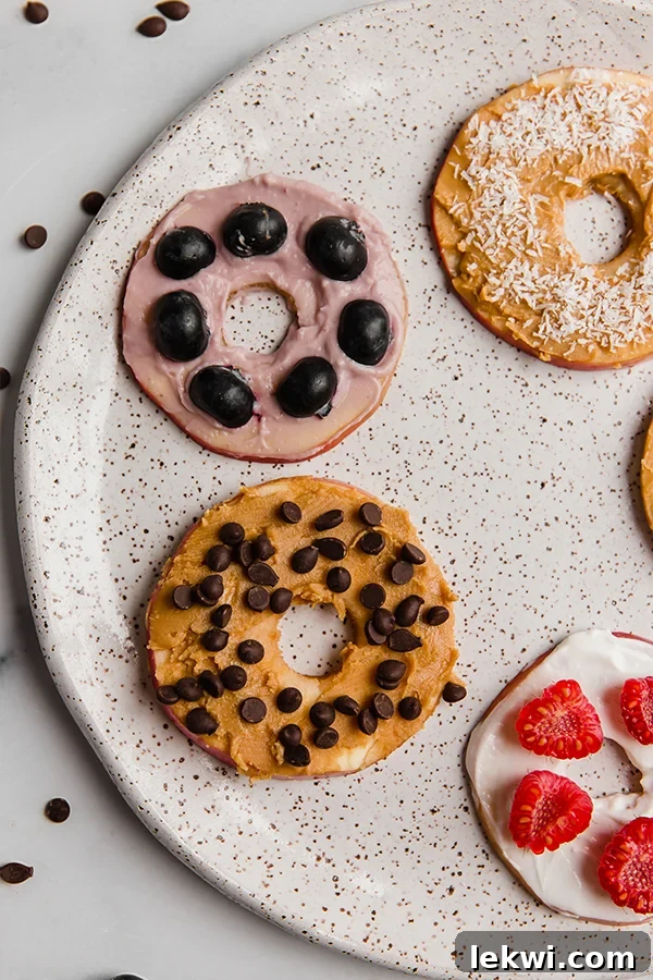 A mouth-watering close-up image of a healthy apple "donut" on a plate, showcasing its delicious toppings and inviting texture.