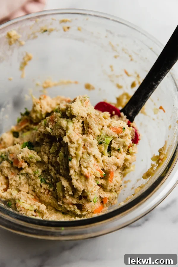 A bowl filled with gluten-free veggie muffin mixture, ready to be scooped.