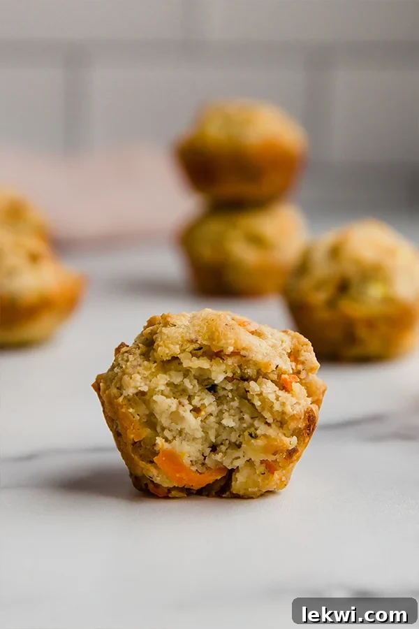 A gluten-free veggie muffin with a bite taken out, showcasing its wholesome interior.