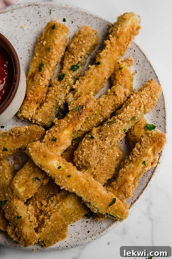 Crispy Pork Panko Zucchini Fries AIP Paleo Egg Free 2 Pork panko coated zucchini fries piled high on a plate, ready to be enjoyed.