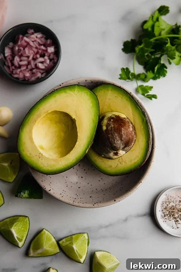 Fresh avocado in a bowl, ready to be mashed into a creamy mixture.