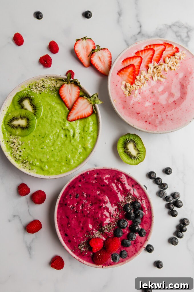 A selection of colorful and healthy smoothie bowls, brimming with fresh fruit and nutritious toppings, rests on a elegant marbled surface, inviting a closer look.