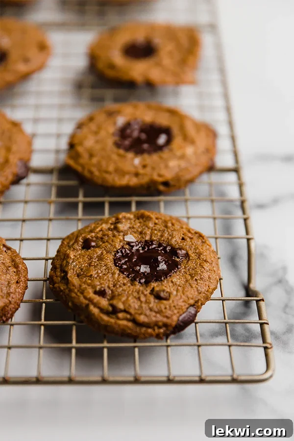 Close-up view of freshly baked flourless almond butter cookies cooling on a wire rack, showcasing their perfect texture.