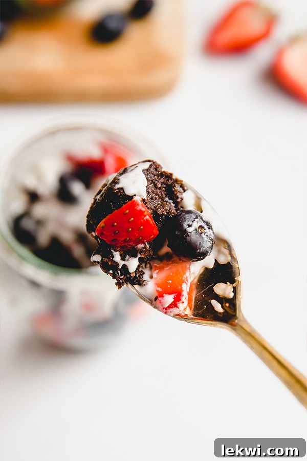 Spoonful of brownie berry parfait showing the perfect blend of brownie, berries, and cream.