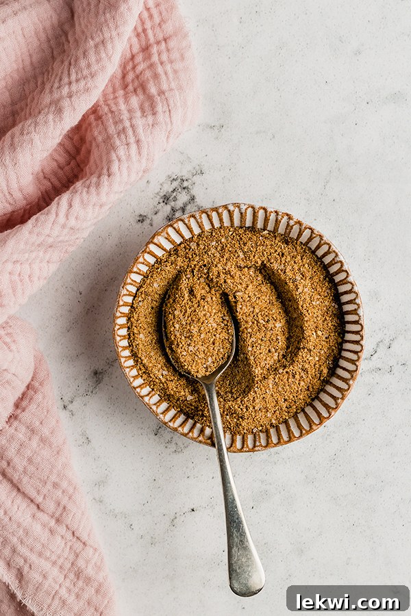 Spice rub mixed in a bowl with a spoon, ready to be applied to pork.