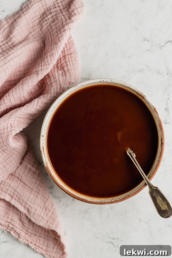 Sauce ingredients mixed together in a bowl with a spoon, ready to be poured.