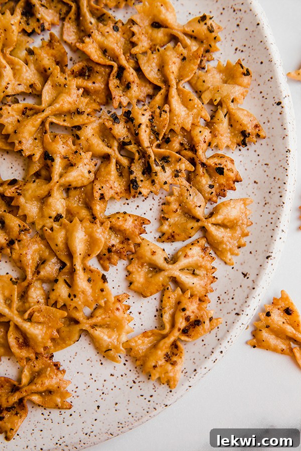 Delicious golden-brown pasta chips served with a dipping sauce, perfect for snacking.
