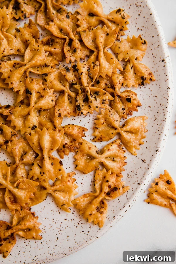 A close-up of a plate brimming with golden, seasoned pasta chips, ready to be enjoyed.