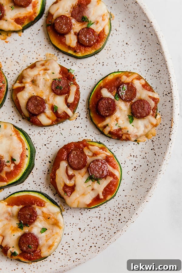 Mini zucchini pepperoni pizza bites on a plate.
