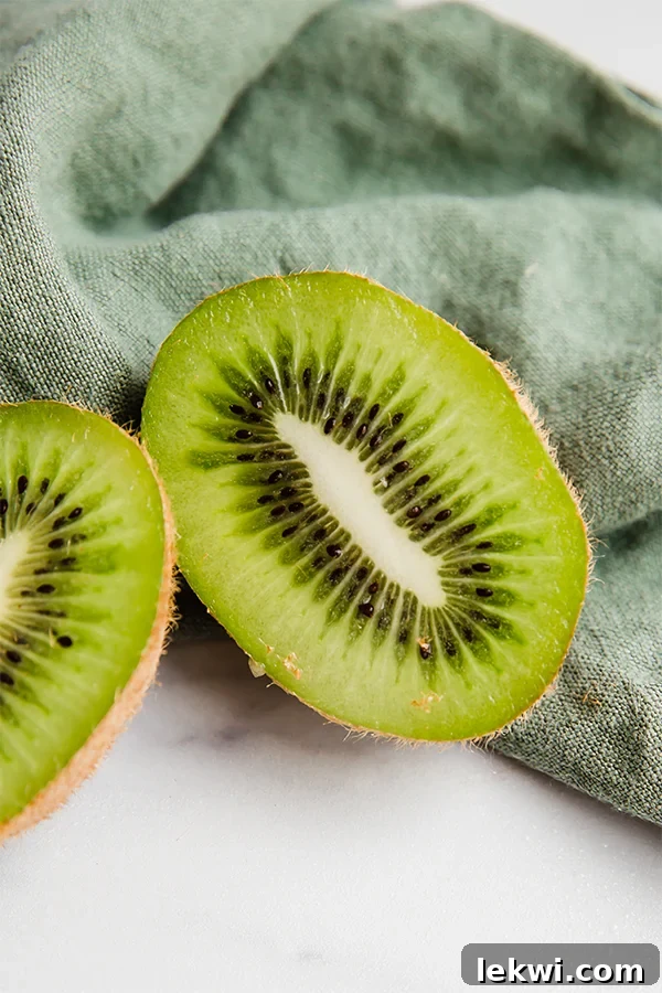 Kiwi sliced in half, showing the green flesh and black seeds. A fresh, natural image representing a key ingredient.