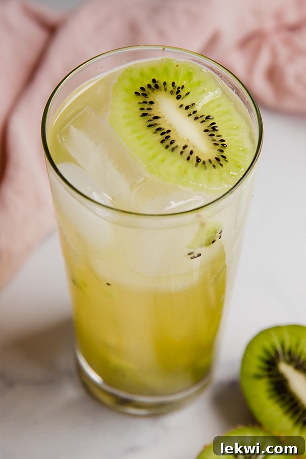 Kiwi refresher in a glass with ice. A close-up shot of the green drink, perfectly chilled and ready to enjoy.