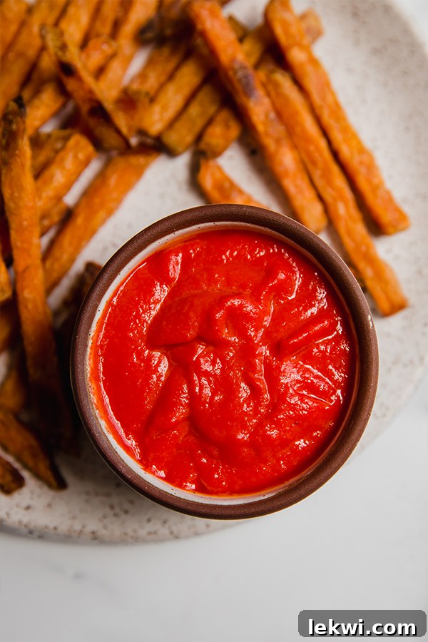 Tomato-free AIP ketchup served on a plate with crispy golden fries, inviting to be dipped.