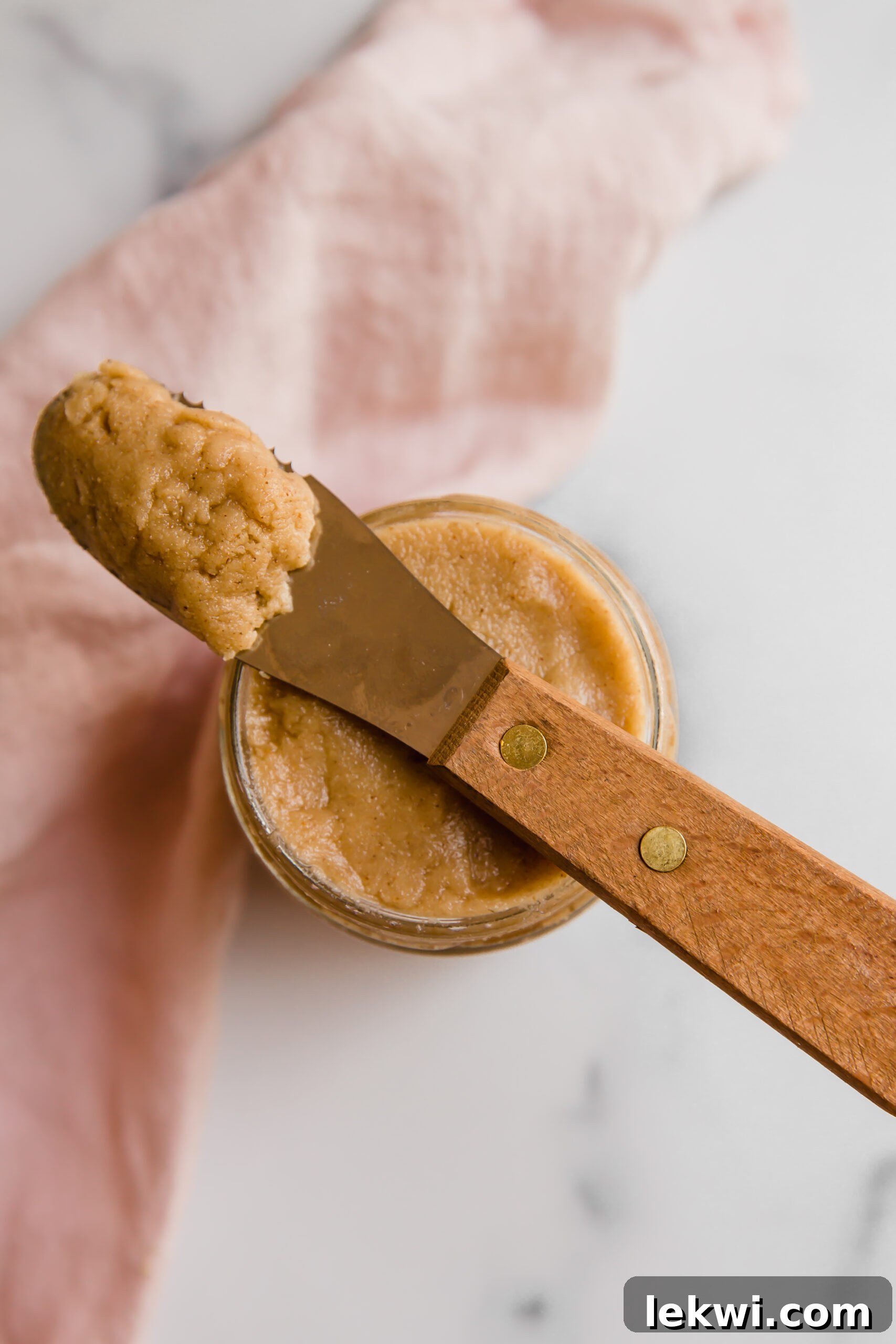 Tigernut butter on a knife, showcasing its smooth texture and rich color.