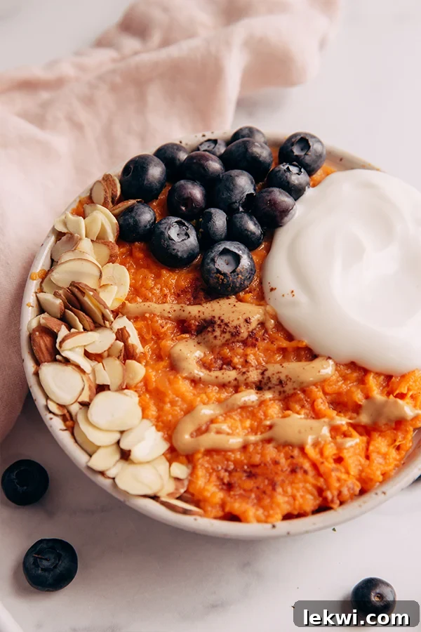 Sweet potato breakfast bowl with nuts and blueberries, ready to be enjoyed.