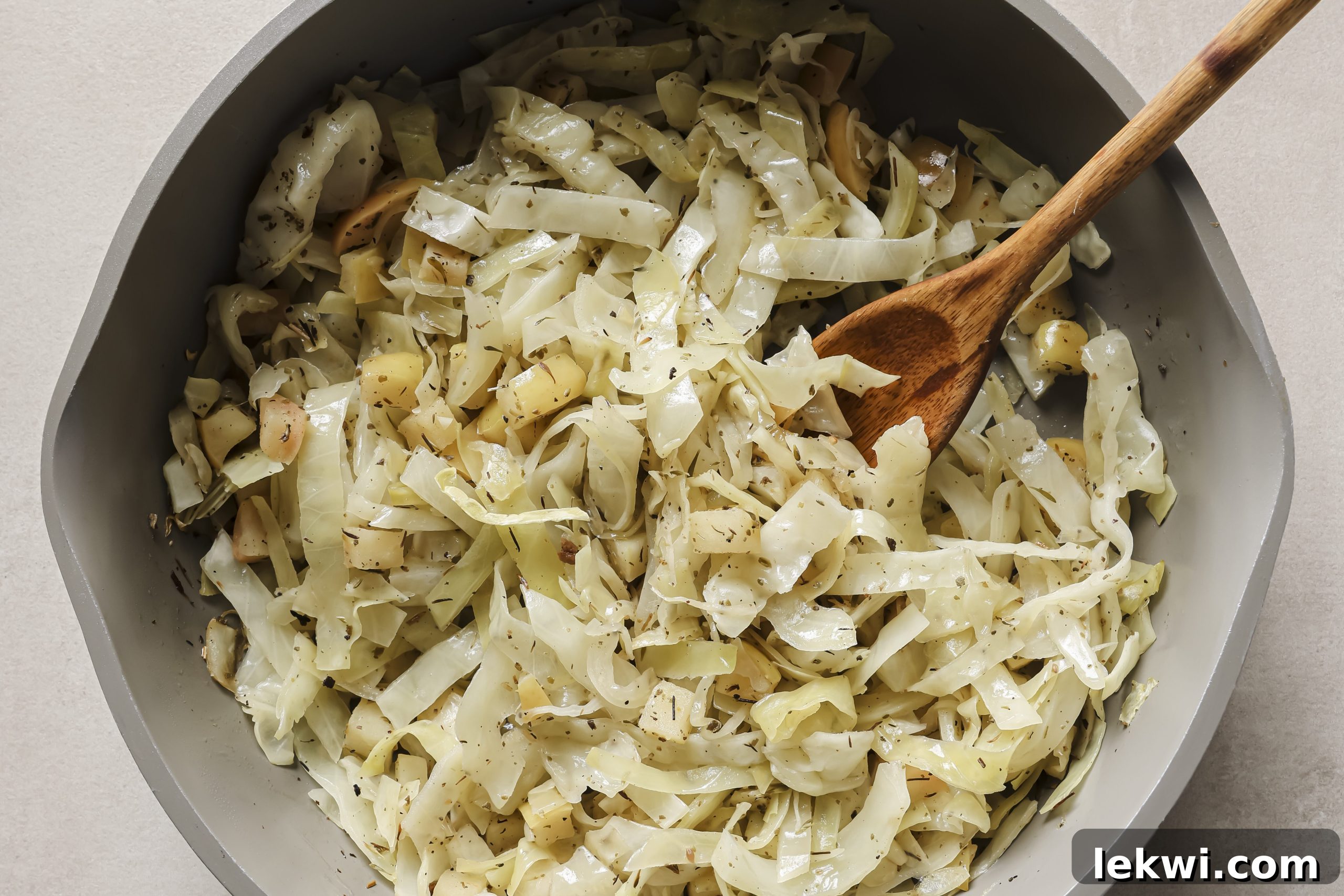 Freshly diced apples and shredded cabbage sizzling and softening in a hot pan, releasing their aromas.