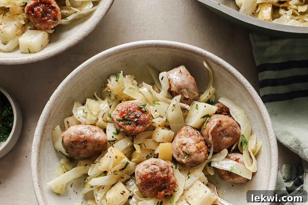 A serving of the Cabbage and Sausage Breakfast Skillet, garnished with fresh parsley, presented in a rustic bowl.