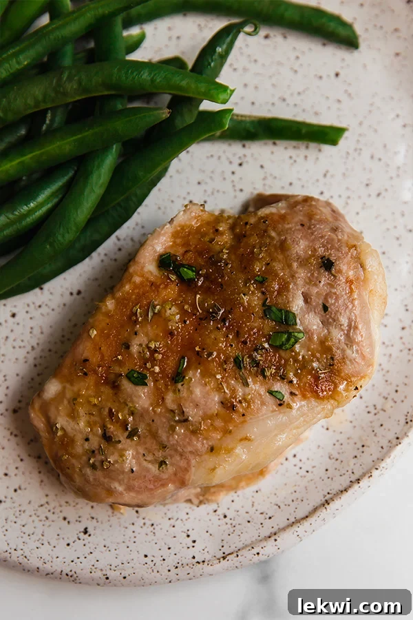 Pork chop on a plate with beans.