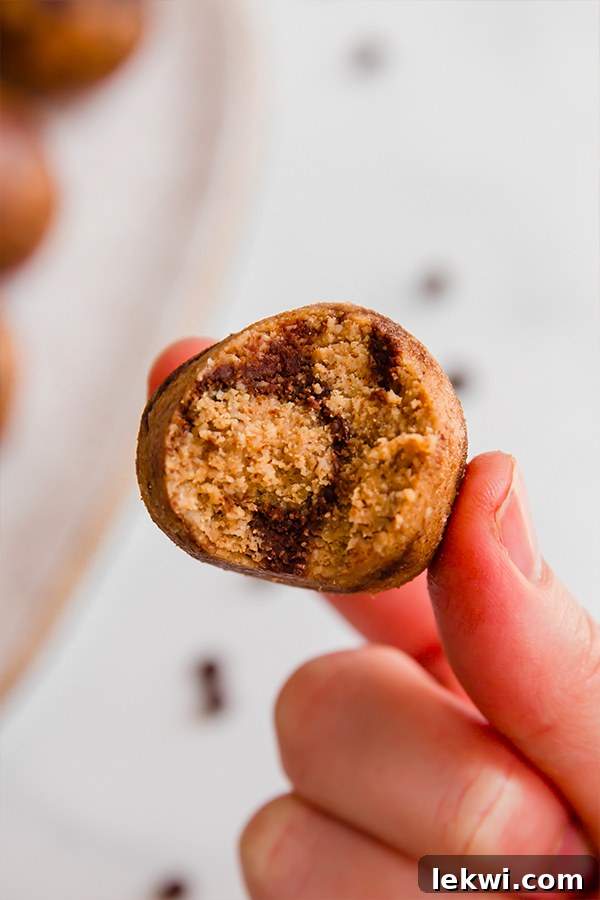 Energy bite held between fingers with a bite taken out