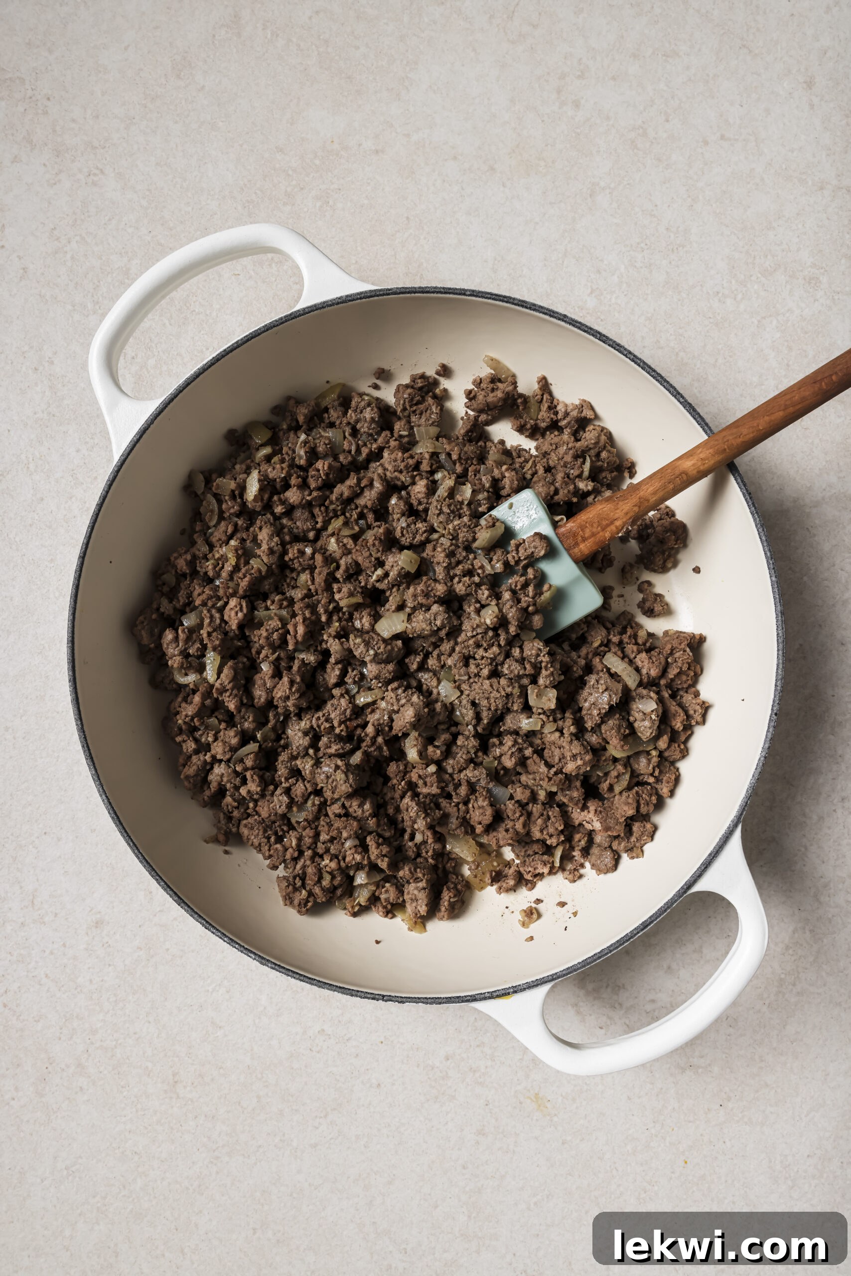 A large white pan with cooked ground beef.