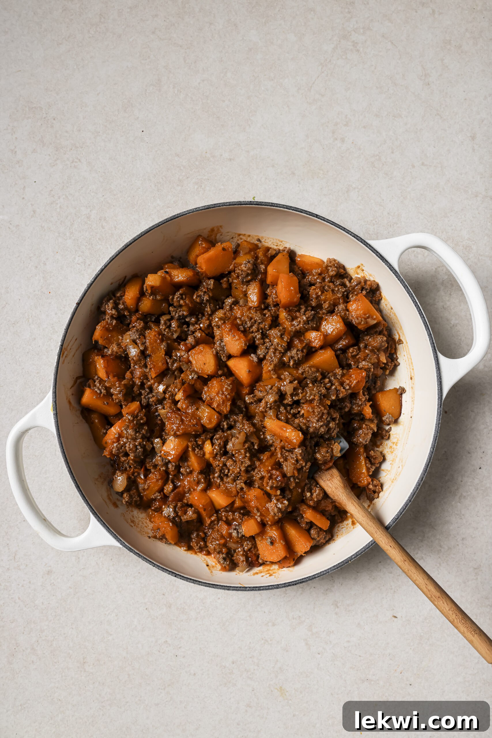 A large white pan with cooked ground beef and sweet potato.