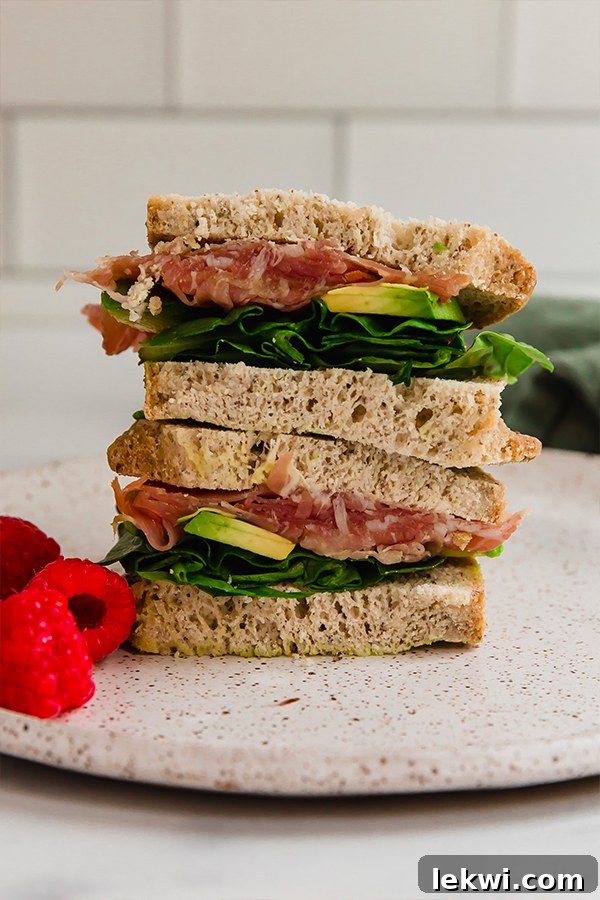 Two halves of a gourmet gluten-free sandwich stacked on each other.