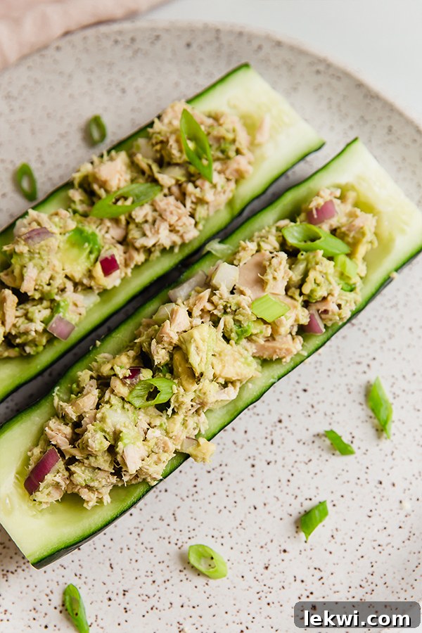 Avocado tuna salad served in cucumber boats on a plate.