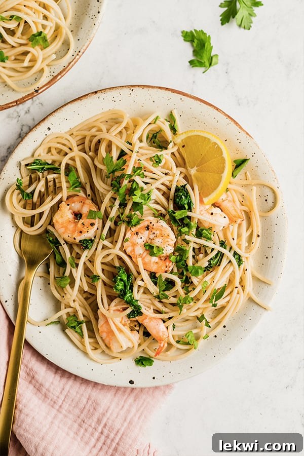 Lemon garlic shrimp pasta on a plate with a fork.