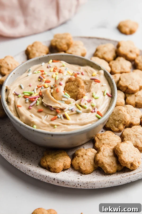 Cookie dipped into a bowl with dip and sprinkles.