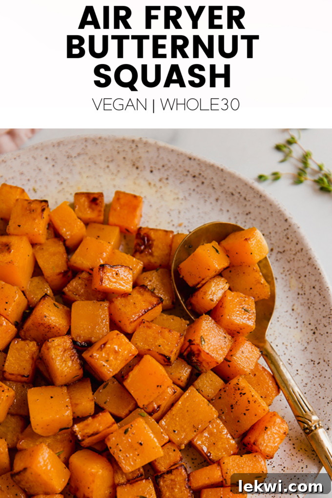 Image displaying cooked butternut squash with text overlay "Air Fryer Butternut Squash Vegan | Whole30."