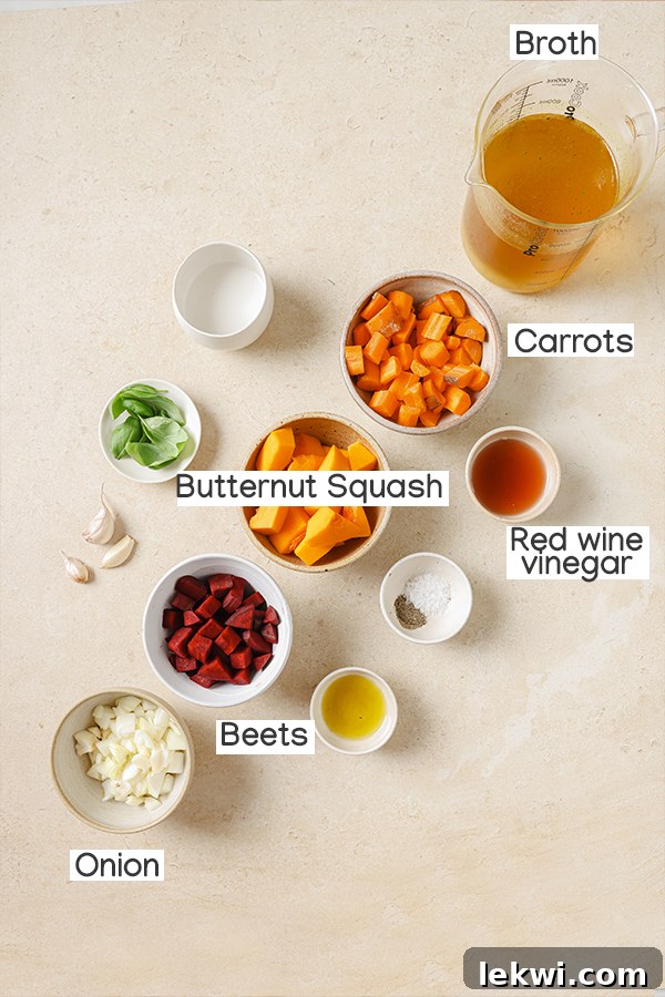 Various ingredients for nightshade-free tomato soup, including red wine vinegar, beets, and carrots on a cutting board.