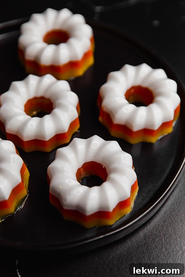Several candy corn mini gelatin molds on a dish.