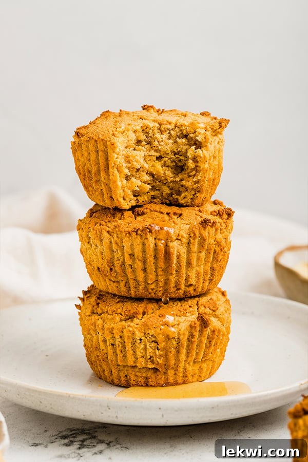 Stack of grain-free cornbread muffins, one of which is missing a bite, highlighting the fluffy interior.