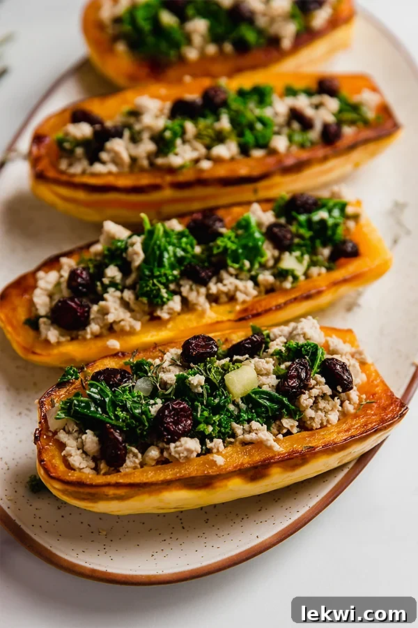 Stuffed Delicata squash on a plate, garnished with fresh herbs.