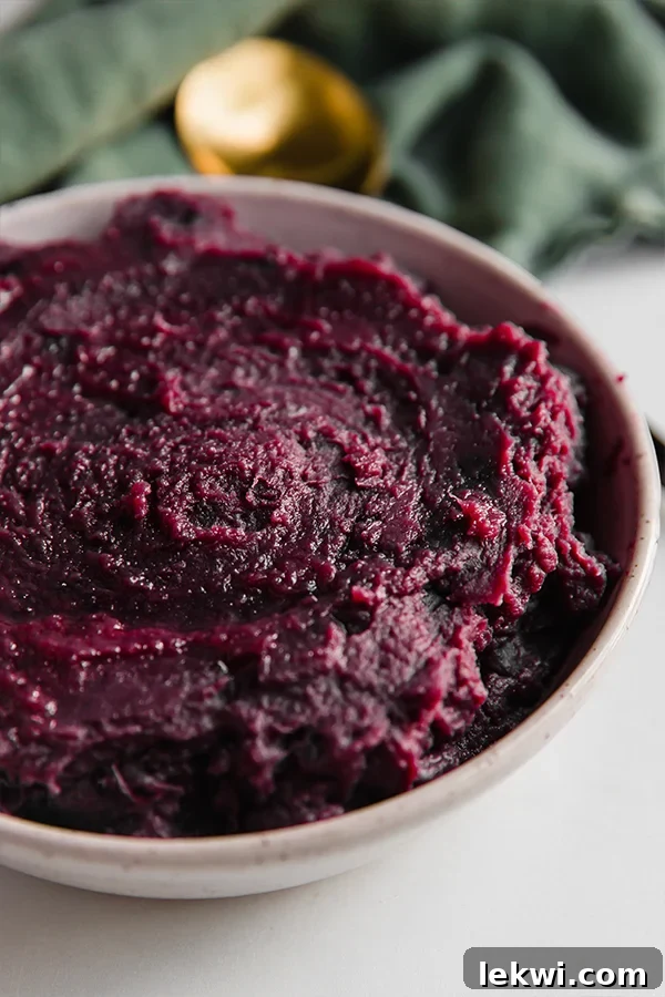 A beautifully presented bowl of purple mashed sweet potatoes, ready for a festive table setting.