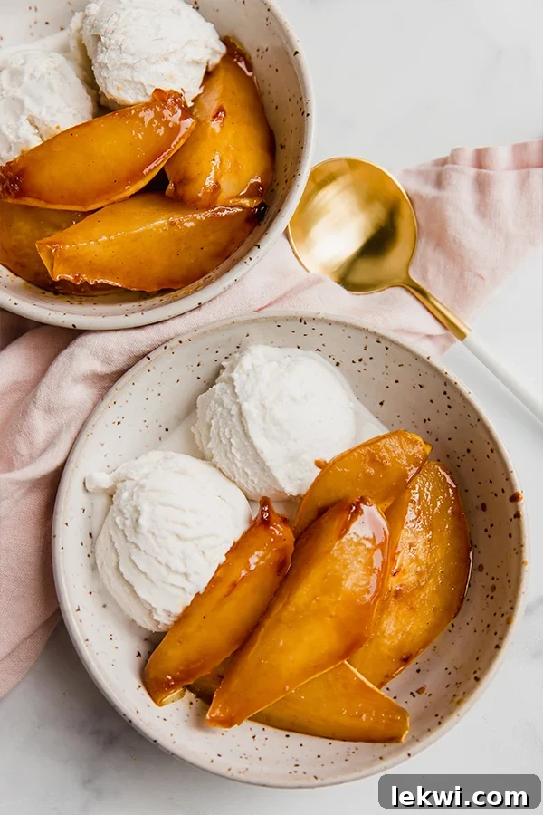 Caramelized pears served in a bowl with ice cream on the side.