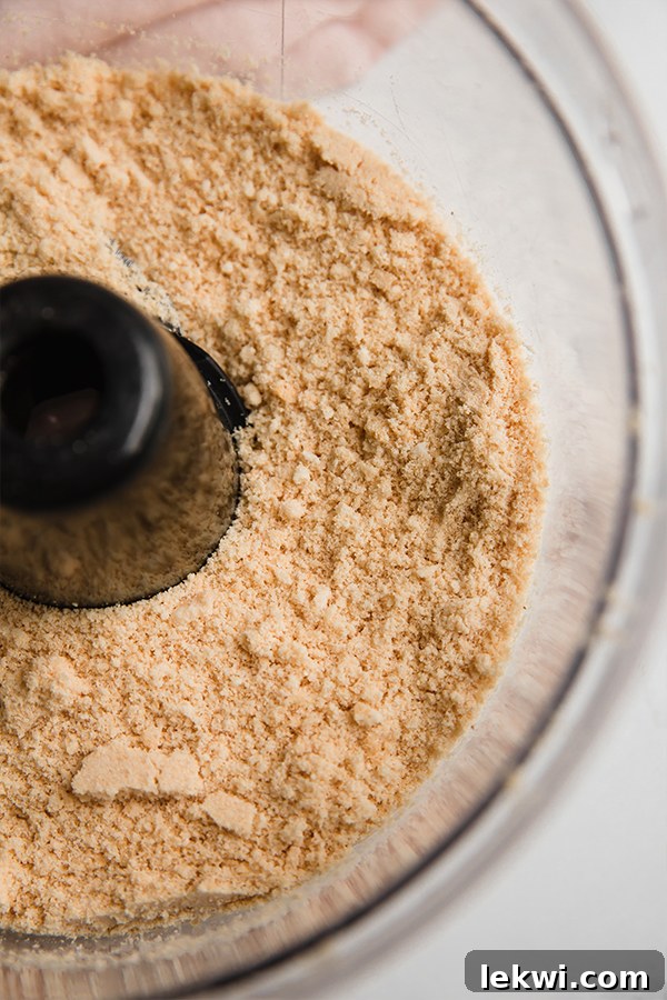 Finely crumbled Lovebird cereal in a food processor, ready for the next step of crust preparation.