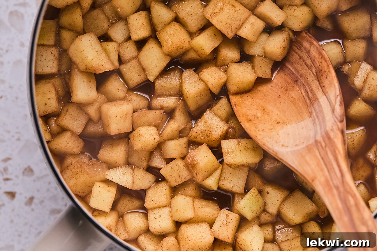 Chopped apple and coconut sugar stewed in a pot. 