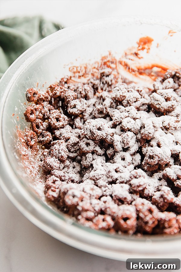 Powdered sugar dusting onto chocolate-covered cereal.