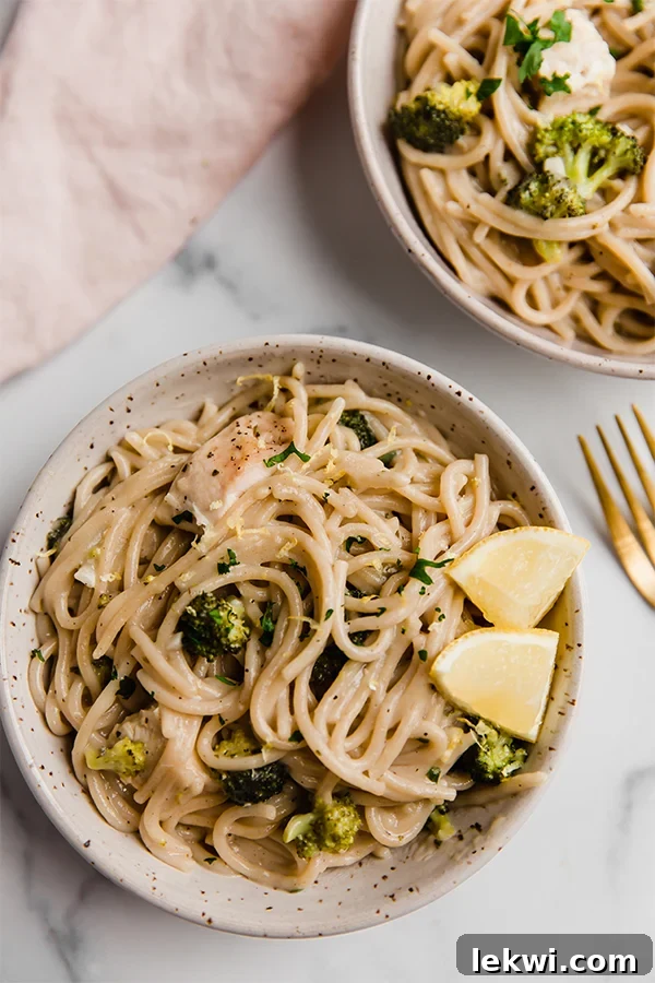 A vibrant bowl of one-pot lemon chicken pasta, garnished with fresh lemon wedges.