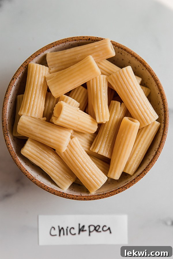 A bowl filled with cooked Banza chickpea pasta, highlighting its appealing color and structure.