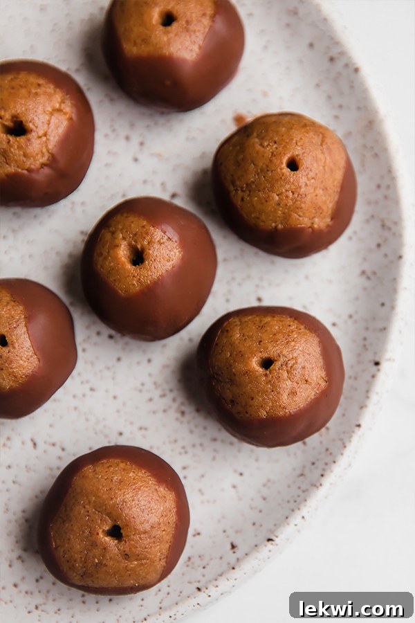 An inviting close-up of several perfectly formed paleo buckeyes on a plate, ready to be enjoyed as a healthy dessert.