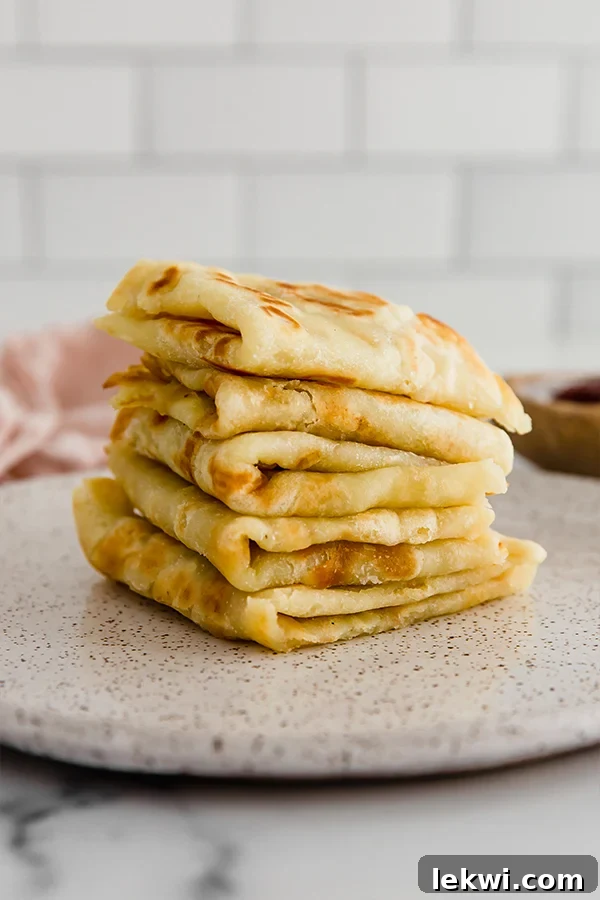 Pile of folded sweet potato Norwegian lefse, showcasing its soft, pliable texture and appealing color.