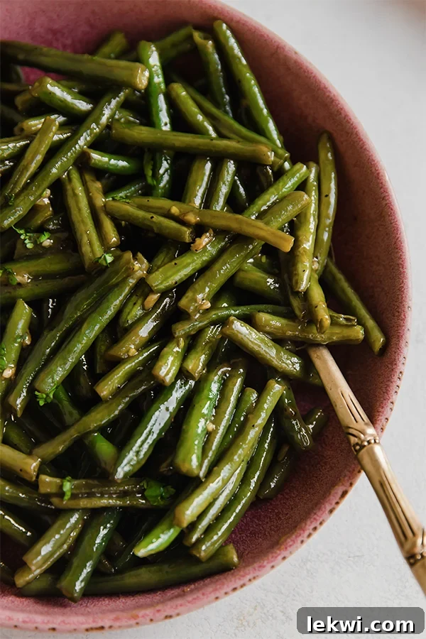 A vibrant bowl of sweet and sour Hungarian green beans, garnished with fresh parsley.