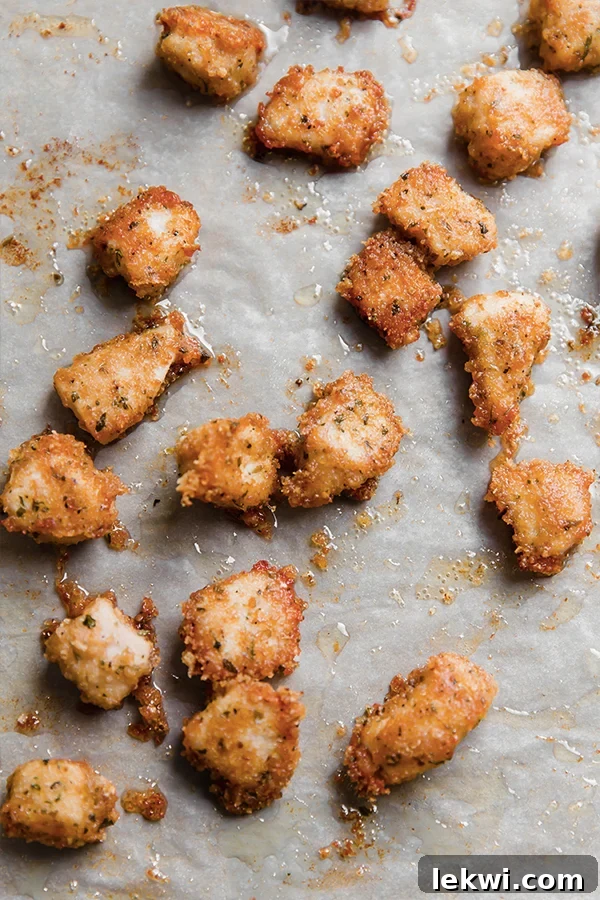 Golden-brown pork panko chicken nuggets on a baking sheet, freshly baked and crispy.