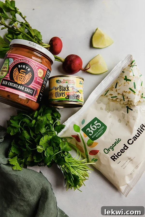 All the wholesome ingredients laid out for making ground beef and cauliflower rice enchilada bowls.