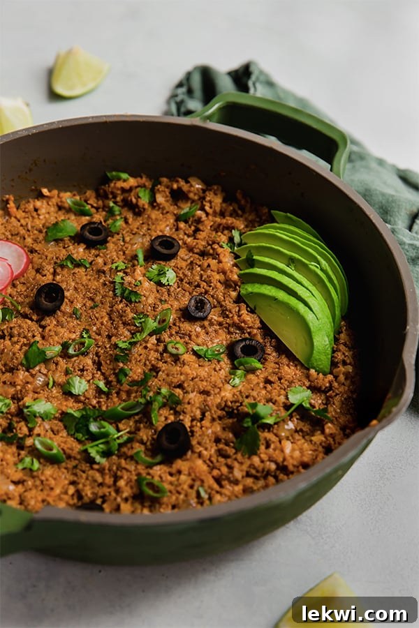 The savory ground beef enchilada mixture simmering beautifully in a skillet on the stove.