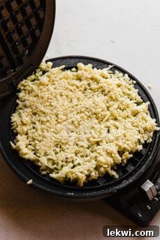 Sweet potato mixture cooking on a waffle iron, showing the transformation into a waffle.